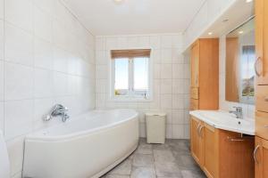 奥勒松Flemsøy的白色的浴室设有浴缸和水槽。