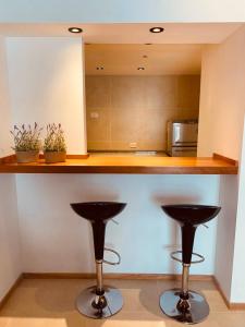 圣卡洛斯-德巴里洛切Tucuman Suite Bariloche的厨房配有2张吧台下凳子