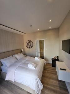 伦敦Hotel CG London的卧室配有一张白色大床和电视。