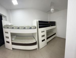 瓜鲁雅NOVO Capitânia Varam 2, dois dormitórios, piscina, churrasqueira, duas vagas de garagem的一间客房内配有两张双层床的房间