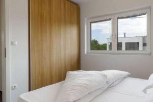 斯拉LUXUS Appartement am Golfplatz und Therme Lutzmannsburg的卧室配有白色的床和窗户
