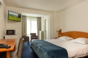 布林瑟姆伊甸公园酒店的配有一张床和一张书桌的酒店客房