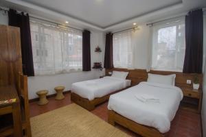 帕坦Yalamul Garden的带2扇窗户的客房内的2张床