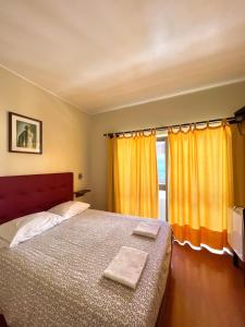 维拉·普拉亚·德·安科拉Abrigo do Portinho的一间卧室设有床和黄色窗帘的窗户