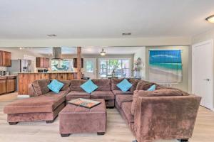 沃尔顿堡滩Family Home with Private Pool and Fenced Yard!的客厅配有棕色沙发和蓝色枕头。