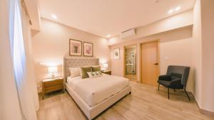 圣多明各Fully Serviced Apartment at Regatta Living - 9F的一间卧室配有一张床和一把椅子