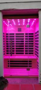 罗克布吕讷-卡普马丹Vue magnifique, piscine privée chauffée et sauna à 10min de Monaco的粉红色的房间,里面装有紫色的灯