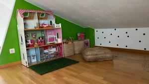 奥洛特Ático de diseño con terraza en el centro de Olot的一间游戏室,里面设有娃娃屋,房间拥有绿色的墙壁