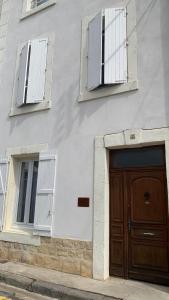 比兹米内瓦Logis de la Foulerie的一座带2扇窗户和木门的建筑