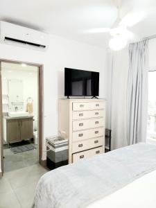 喀巴里特Ocean Palms - 1Bed 1Bth King Suite Condo的一间卧室配有一张床和一个带电视的梳妆台