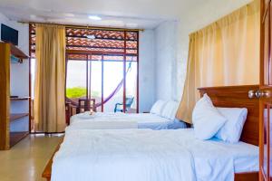 巴克里索莫雷诺港Royal Galápagos Inn的酒店客房设有两张床和窗户。