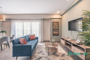 Los PradosChic Fully Serviced Apartment at Regatta Living II - 705的客厅配有蓝色的沙发和电视