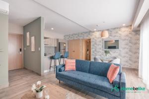 Los PradosChic Fully Serviced Apartment at Regatta Living II - 705的一间带蓝色沙发的客厅和一间厨房