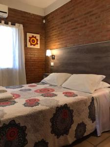 米娜克拉韦罗La Osadia Cabañas y Suites Solo Adultos的一间卧室配有一张带花卉图案的毯子的大床