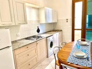 福洛尼卡appartamento Via Siena 1的厨房配有木桌和桌子,还设有用餐室。