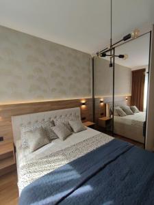 巴尼亚卢卡GRAND LUX APARTMENTS的卧室配有一张白色大床和镜子