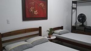 乌巴图巴APARTAMENTO PRÓXIMO A PRAIA PISCINA E AREA GOURMET的一间卧室设有两张床和盆栽植物