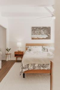 普林斯维尔Puamana Maluhia - Two Bedroom / Two Bath Condo的卧室配有一张床,墙上挂有绘画作品