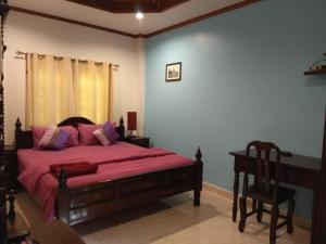 三百岭斯特拉度假酒店的一间卧室配有一张带粉红色床单和椅子的床