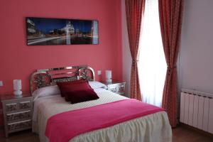 马德里Casa de Huéspedes Galaica的一间卧室配有一张粉红色墙壁的床