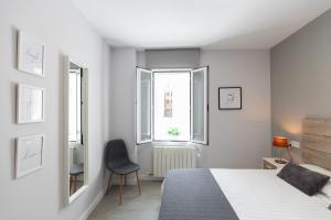 萨拉戈萨Apartamento Foro Romano的一间白色卧室,配有床和2个窗户