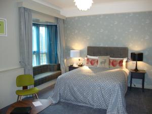 克罗伊登Coulsdon Manor Hotel and Golf Club的一间卧室配有一张床、一把椅子和一张沙发