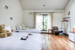 美瑛町緩慢‧北海道民宿的酒店客房带两张床,上面有泰迪熊