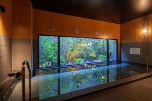 四国中央市Hotel Route Inn Shikoku Chuo的一个带大窗户的房间内的游泳池