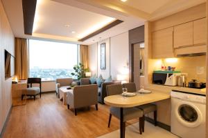 曼谷曼谷茉莉花度假酒店的厨房以及带桌椅的起居室。