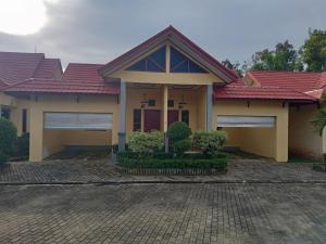 明古鲁省RedDoorz @ Puncak Tahura Hotel Bengkulu Tengah的一座有红色屋顶和车道的房子