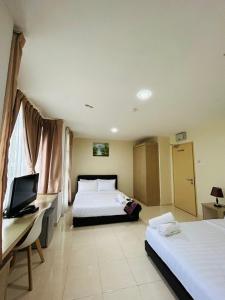 加央Noor Hotel Kangar的酒店客房配有两张床和一张书桌