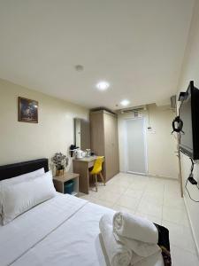 加央Noor Hotel Kangar的一间卧室配有一张床、一台电视和一张书桌