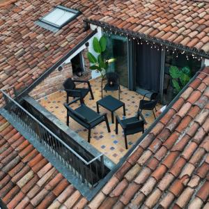 阿斯蒂Centro storico-Dimora con terrazza- Wi-Fi e Ac的享有带椅子和屋顶的天井的顶部景致。