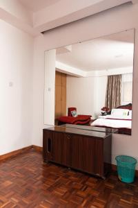 内罗毕spacious & stylish 4bdr kileleshwa的卧室配有大镜子,位于床上方