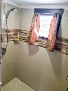南迪Masters 2 Bedroom Apartment Westfield的一间带窗帘和窗户的淋浴的浴室
