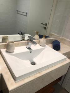 拉斯阿尔卡麦2 Bedroom Deluxe Beach Apartment Al Marjan的浴室设有白色水槽和镜子