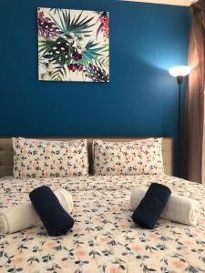 拉斯阿尔卡麦2 Bedroom Deluxe Beach Apartment Al Marjan的一间卧室配有带枕头的床铺和蓝色的墙壁
