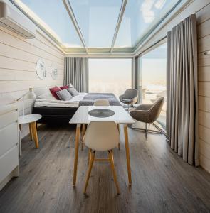 HyrynsalmiUkkohalla Sky Cabin Glass Suite的卧室配有一张床和一张桌子及椅子