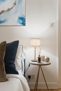 伦敦Notting Hill Apartment的一间卧室配有一张床和一张带台灯的桌子