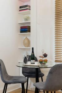 伦敦Notting Hill Apartment的一张桌子、两把椅子和一瓶葡萄酒