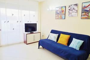 罗列特海岸Precioso apartamento con piscina y jardín propio的客厅配有蓝色的沙发和电视