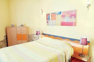 罗列特海岸Precioso apartamento con piscina y jardín propio的一间卧室配有一张床和一个带两盏灯的梳妆台。
