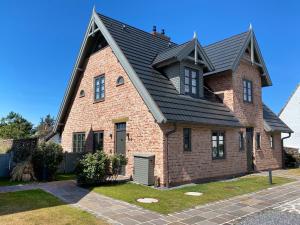 韦斯特兰Ferienhaus Inselwind Sylt的黑色屋顶的棕色砖屋