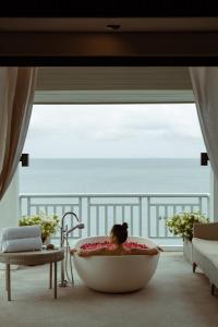攀瓦海滩Amatara Welleisure Resort的窗户间浴缸里的女人