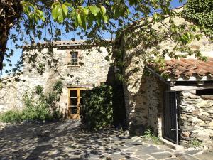 蒙塞尼Ca l'Agnès的一座古老的石头建筑,有一扇门和一棵树