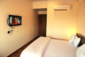 斋浦尔The Sarai, Hotel的酒店客房设有一张床和墙上的电视
