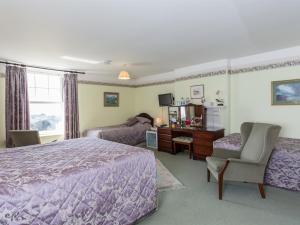 西卢港Bucklawren Farm的一间卧室配有一张床、一张桌子和一把椅子