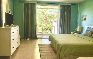 格兰岛Chalianglom Resort Kohlarn的一间卧室配有一张床、一台电视和一个窗口