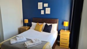弗雷泽堡达夫隆酒店的一间卧室配有一张蓝色墙壁的床和两盏灯。