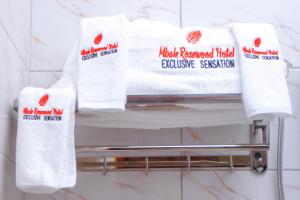 MbaleMbale Rosewood Hotel的浴室毛巾架上的一堆毛巾